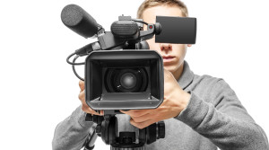 Video camera operator working with his professional equipment isolated on white background